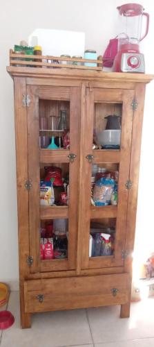 drewniana szafka z jedzeniem i innymi rzeczami w obiekcie Quarto Rustico em Alfenas w mieście Alfenas
