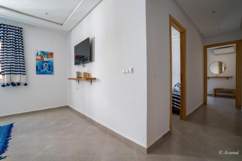 a living room with white walls and a hallway at Vista Verde in Oulad Akkou