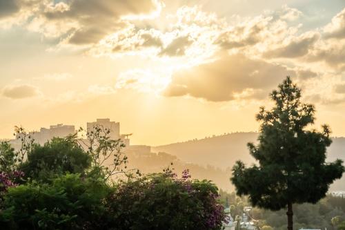 a view of a city with the sun shining through the clouds at Historical 2 bedrooms home with a Private Jacuzzi in ‘En Kerem