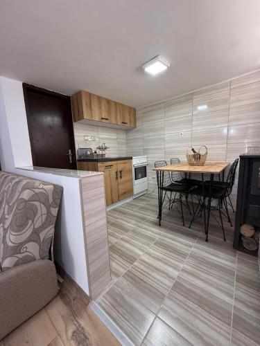 a kitchen with a table and a dining room at Šumski mir in Despotovac