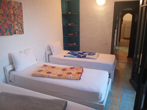 Duplex Ambre dans Jardins de la lagune Pour les familles في الوليدية: سريرين في غرفة مع وسادة في الأعلى