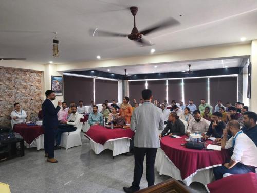 a group of people sitting at tables in a room at Aliza Inn And Suites By SRS Hotels in Dharamshala
