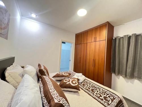 a bedroom with a bed and a wooden cabinet at Casa e Negócios in Mairiporã