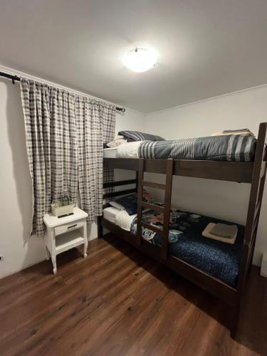 a room with two bunk beds and a table at Tu Espacio RE - Casa cerca del Aeropuerto in Santiago
