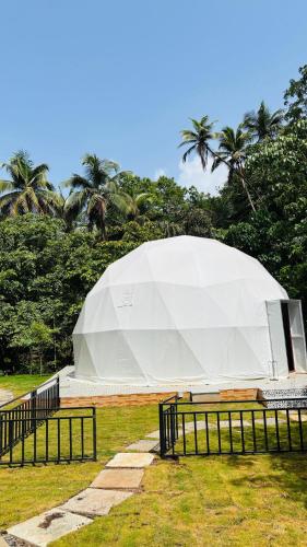 a large white tent in a field with trees at Indulge House in Revora