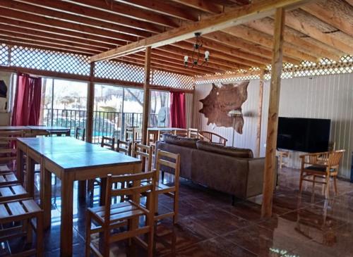 a living room with a couch and a table and chairs at Desayuno Habitación TourLodge in San Pedro de Atacama