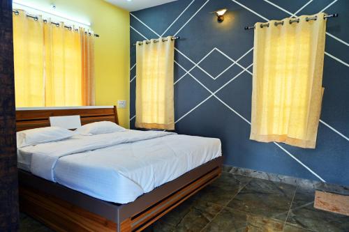 a bedroom with a large bed with yellow curtains at Suhas Nest in Mysore