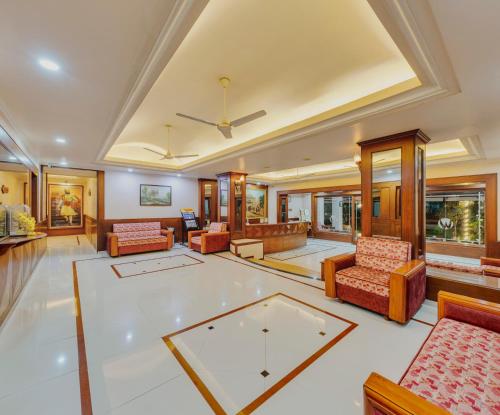 a living room filled with furniture and a table at Hotel Woodland in Kolhapur