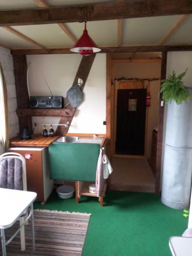 a small kitchen with a sink and a table at OUDenTEAK in Euscheid