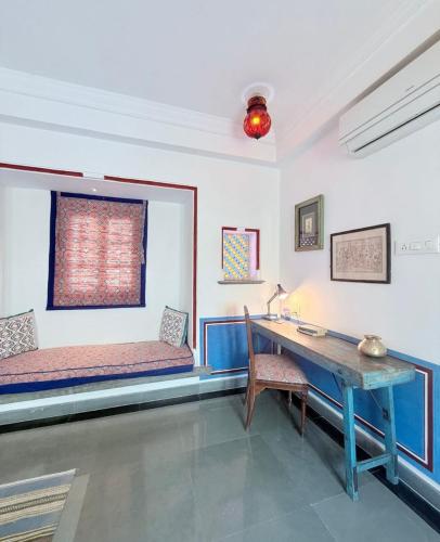 a room with a desk and a table and a window at Little Garden Guest House in Udaipur