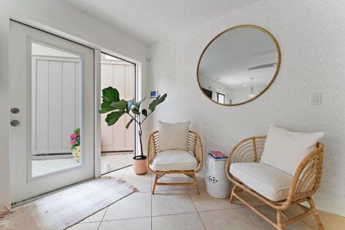 a living room with two chairs and a mirror at Beachside Modern Wellness Villa with Spacious Patio in Jupiter