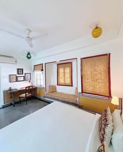 a living room with a bed and a desk at Little Garden Guest House in Udaipur