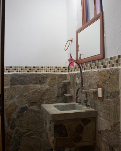 a bathroom with a stone sink and a mirror at Kasa Jaguar in Mazunte
