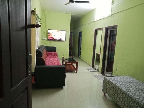a living room with a couch and a tv at Thulasitharayil in Vagamon