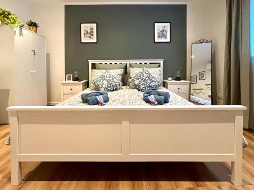 a large white bed in a room with a mirror at COZEE - Air-Conditioned Apartment with Netflix in Kaiserslautern