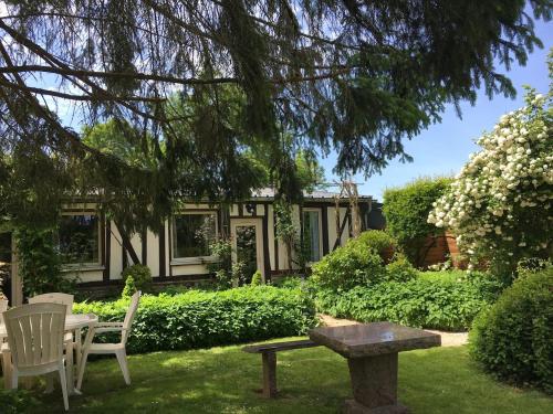 a house with a picnic table and chairs in the yard at Le Logis Fleurs et jardins de Pitry in Thierville