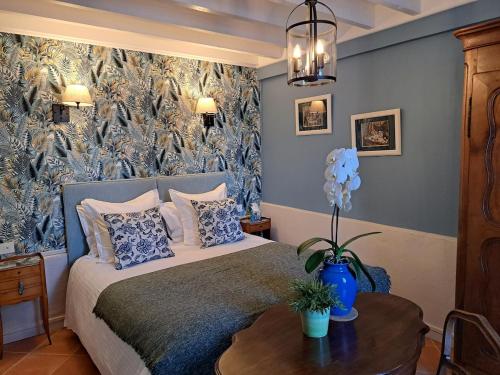 a bedroom with a bed with a table and a mural at Le Logis Fleurs et jardins de Pitry in Thierville