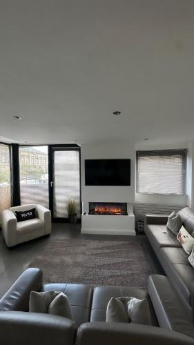 a living room with a couch and a fireplace at LUXURY Apartment Belfast City Centre overlooking Custom House Square in Belfast