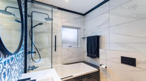 un baño con ducha y bañera en Luxury Villa at Riviera Hotel Hartenbos, en Mossel Bay