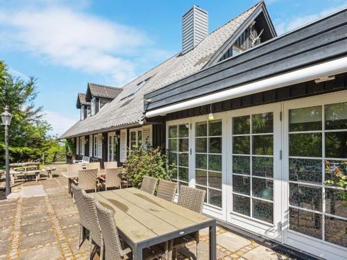 an outdoor patio with a wooden table and chairs at 19 person holiday home in Løgstør-By Traum in Trend
