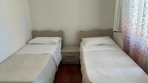 two beds in a small room with white sheets at il campanile in Gaeta