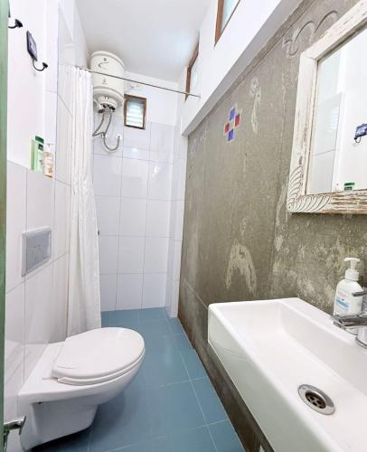 a bathroom with a white toilet and a sink at Little Garden Guest House in Udaipur