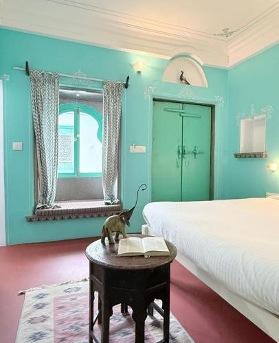 a bedroom with a bed and a cat sitting on a table at Little Garden Guest House in Udaipur