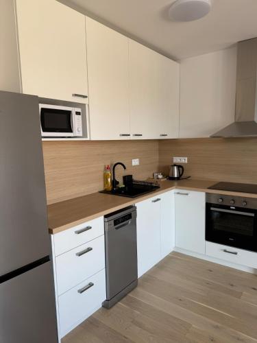 a kitchen with white cabinets and a stove top oven at Bratislava in Nivy