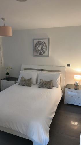 a bedroom with a white bed with two pillows on it at LUXURY Apartment Belfast City Centre overlooking Custom House Square in Belfast