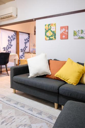 a couch with pillows on it in a living room at DK Matsunaga House in Fukuyama