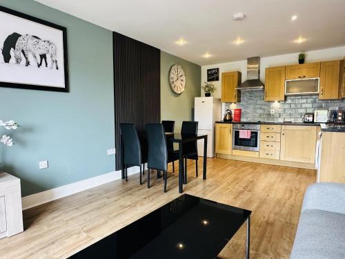 a kitchen and living room with a table and chairs at Grand Central Apartments in Derby