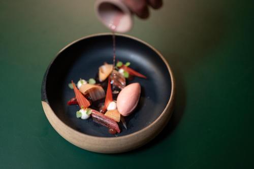 a bowl of food on a green table at Hotel Muchele in Postal