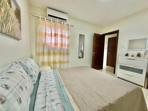 a bedroom with a bed and a window at Mellieha Seaview Penthouse in Is-Sellum