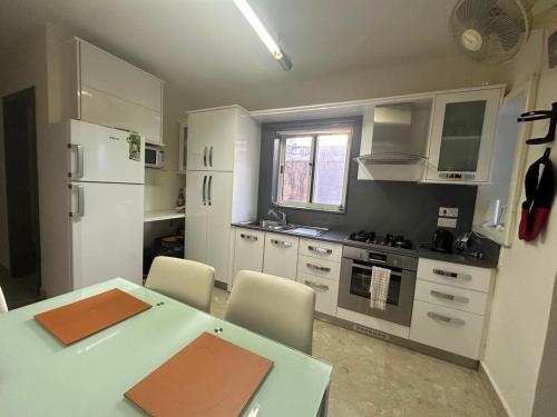a kitchen with a table and chairs and a refrigerator at Mellieha Seaview Penthouse in Is-Sellum