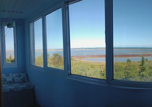 a room with three windows looking out at the water at Wild lakes home in Burgas City