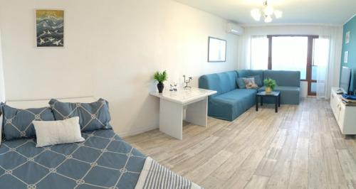 a living room with a blue couch and a table at Wild lakes home in Burgas City