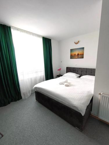 a bedroom with a large bed and a large window at Dumbravii House in Sibiu