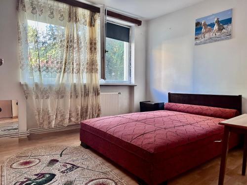 ein Schlafzimmer mit einem roten Bett und einem Fenster in der Unterkunft Centru Vechi Craiova in Craiova