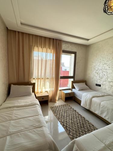 a bedroom with two beds and a window at imsouane sea house in Imsouane