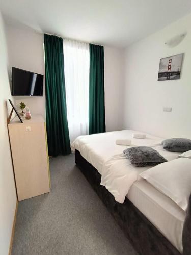 a hotel room with two beds with green curtains at Dumbravii House in Sibiu