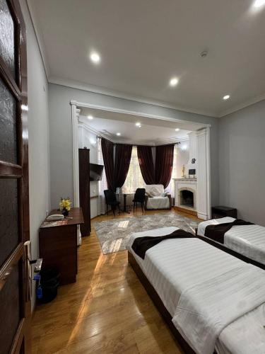 a bedroom with two beds and a living room at Shuxrat hotel in Chilanzar
