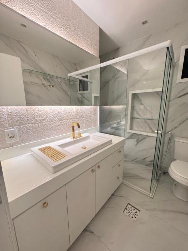 um banheiro com pia, chuveiro e vaso sanitário em Altos do umarizal em Belém