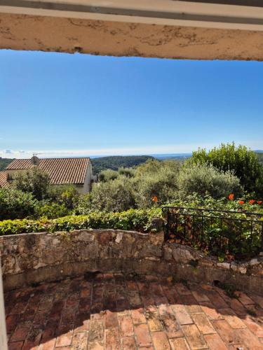 a view from a window of a patio with flowers at La Ruchanne in Tourrettes-sur-Loup