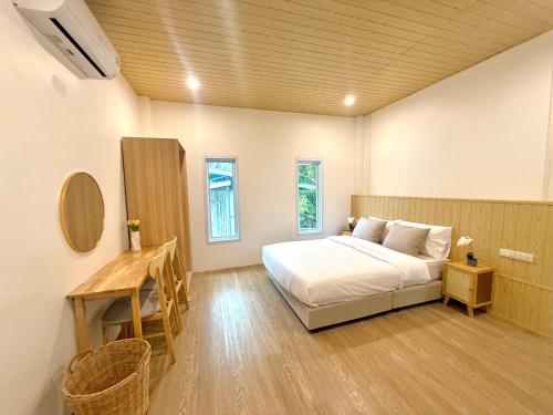 a bedroom with a bed and a table and a desk at Montara villa Chaloklum Koh phangan in Chaloklum