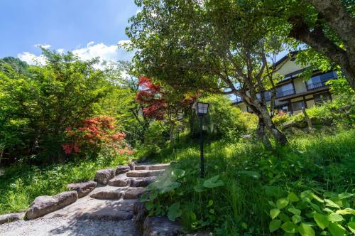 a stone path in a garden with trees and a building at Yaki no Yu - Vacation STAY 29804v in Takayama