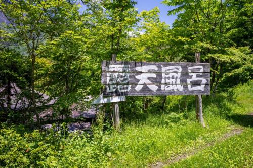 a sign in the grass next to some trees at Yaki no Yu - Vacation STAY 29804v in Takayama