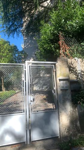 an open gate with a fence in a yard at Affittacamere via Moncolano mare Barcola in Trieste