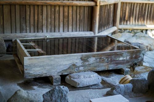 a wooden trough sitting on some rocks in a building at Yaki no Yu - Vacation STAY 29804v in Takayama