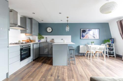 a kitchen and dining room with blue walls and a table at The Penthouses, 8 Albion Mews in Chester