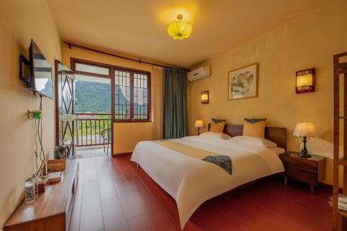 a bedroom with a large bed and a large window at Secret Courtyard Resort Hotel in Guilin